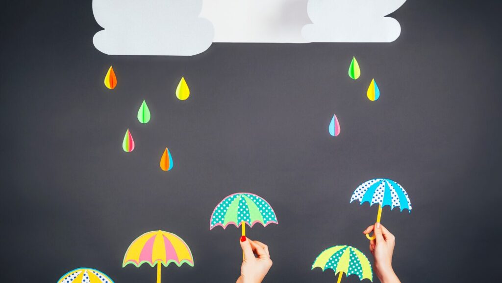 雲から雨が降って傘をさしているイラスト
