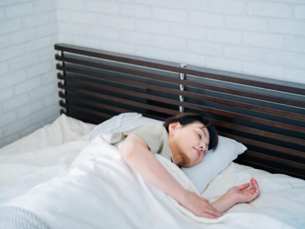 ベッドで横向きに寝る女性