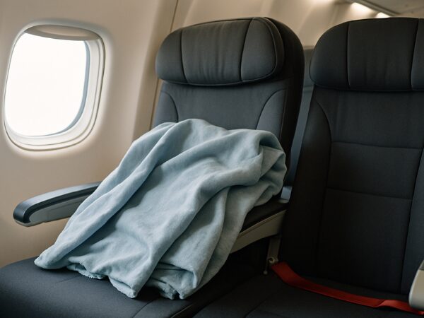 飛行機の座席に置かれたグレーのブランケット