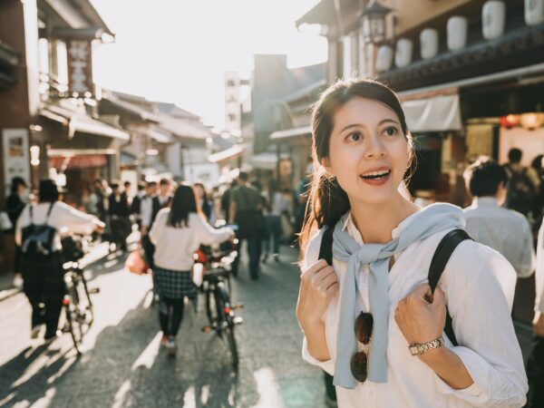 人混みの中をリュックを背負って歩く女性