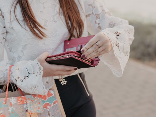 ピンク色の財布からカードを出そうとしている女性