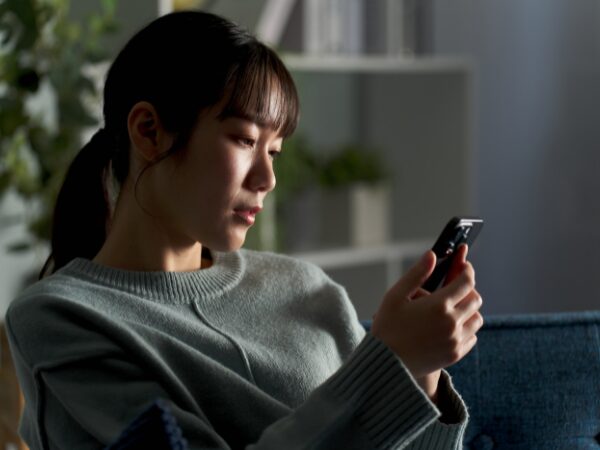 スマホを見つめて元気のない女子