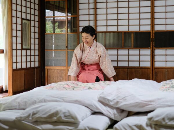 部屋の布団を敷く仲居さん